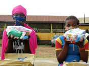 Girls show off the contents of their dignity kits from Plan International