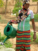 Aissata, 22, waters the vegetables in the community garden