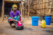 Beti, 15, washes dishes outside the family's shelter