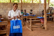 Amina, 11, with her school kit provided by Plan International